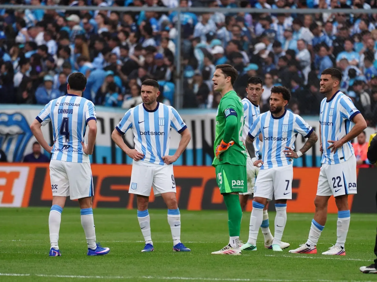 Racing Club players leave the field after the 1-1 draw against Independiente in the Avellaneda derby, with fans showing visible disappointment